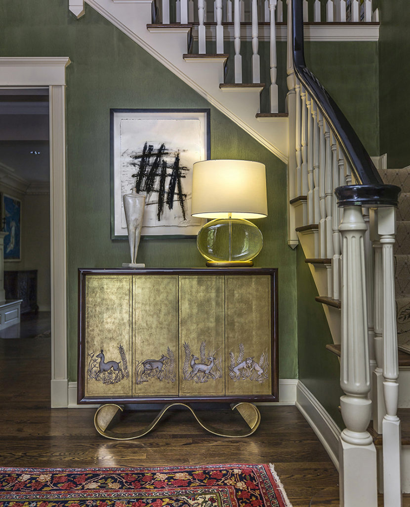 Foyer with green walls and custom chest